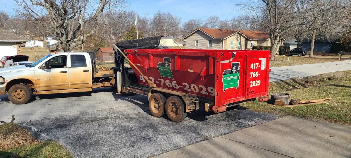 Roll-off dumpster set beside a house during a demolition job.