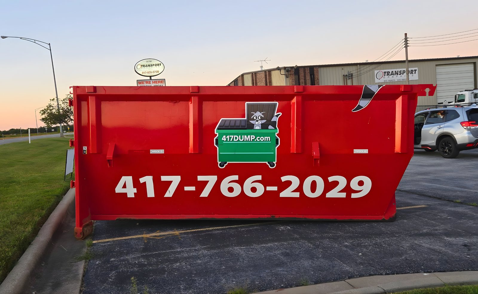 Side view of a tall-walled red 417 Dumpster Rental roll-off, the 20-yard box.