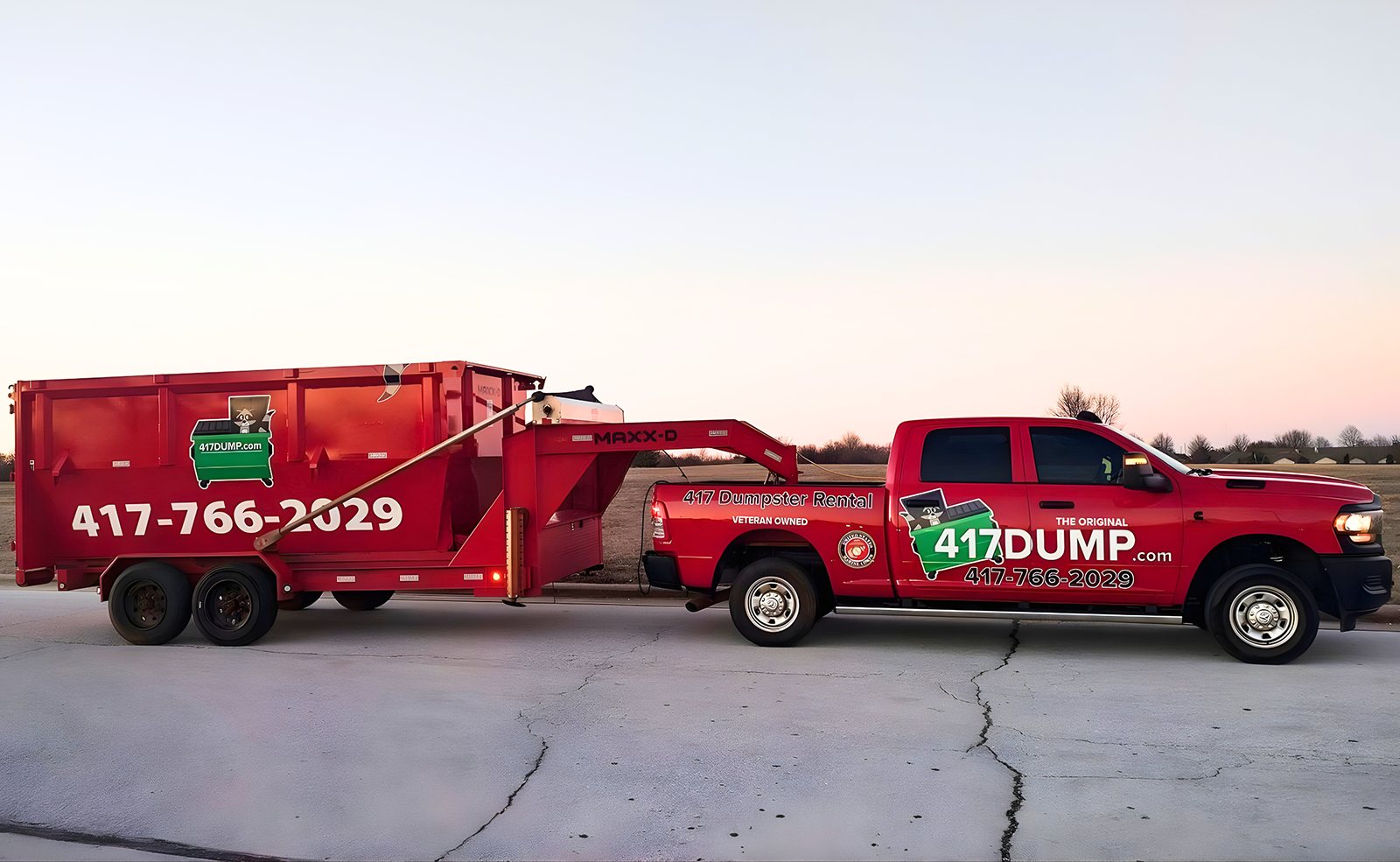 A 417 Dumpster Rental pickup and trailer parked with a loaded dumpster
